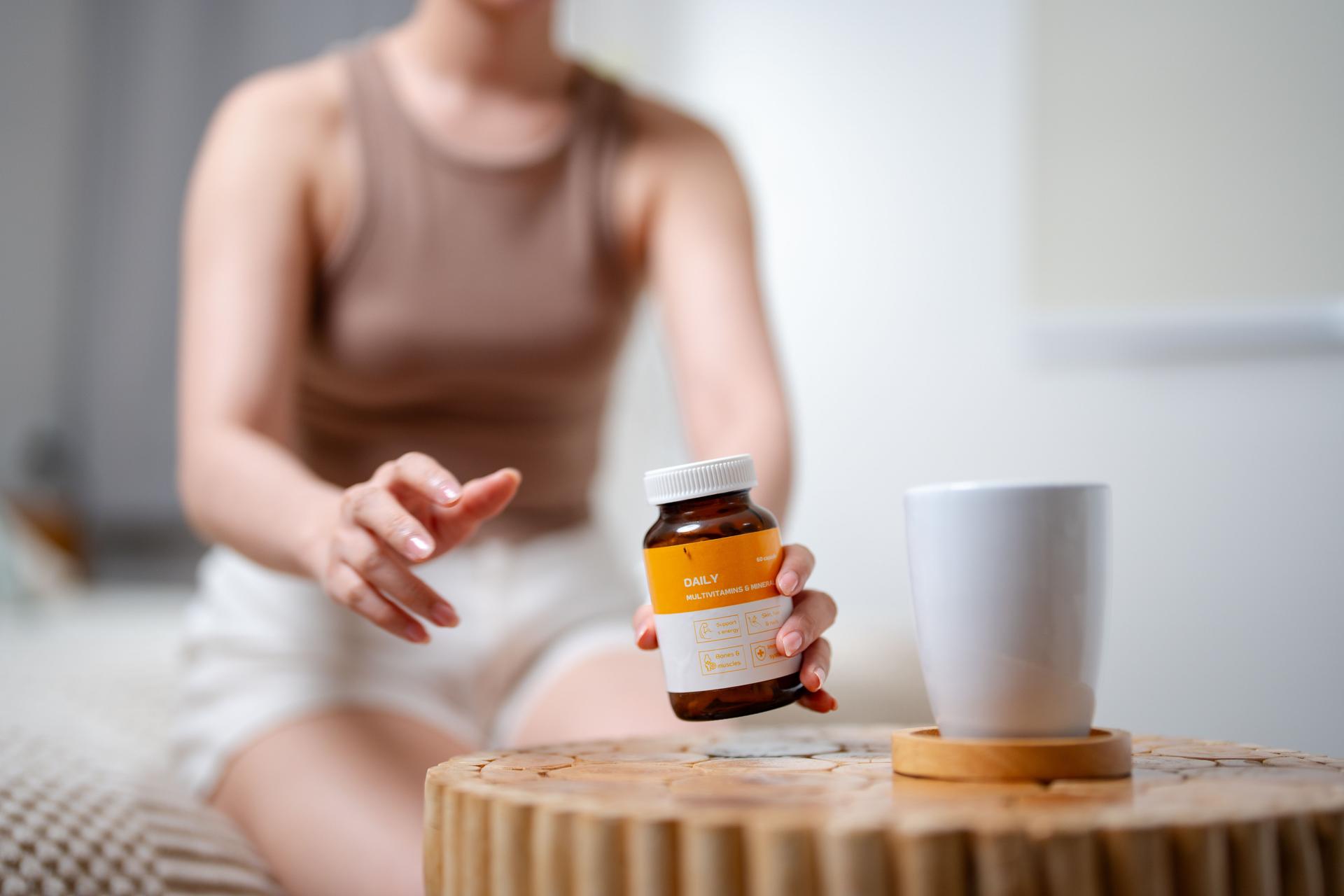 Young woman carefully reading the nutritional label on her supplement container