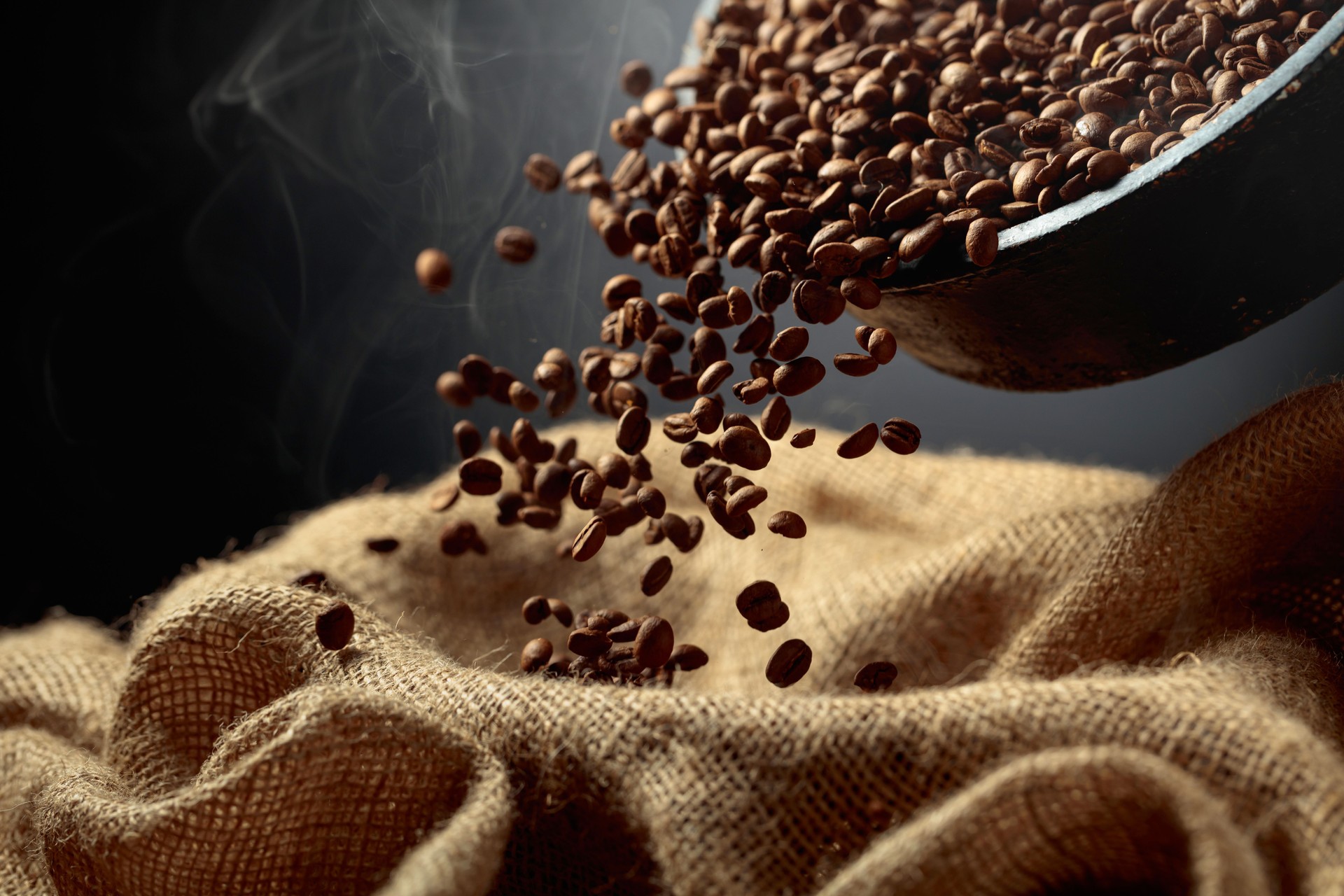 Freshly roasted coffee beans are poured into a bag.